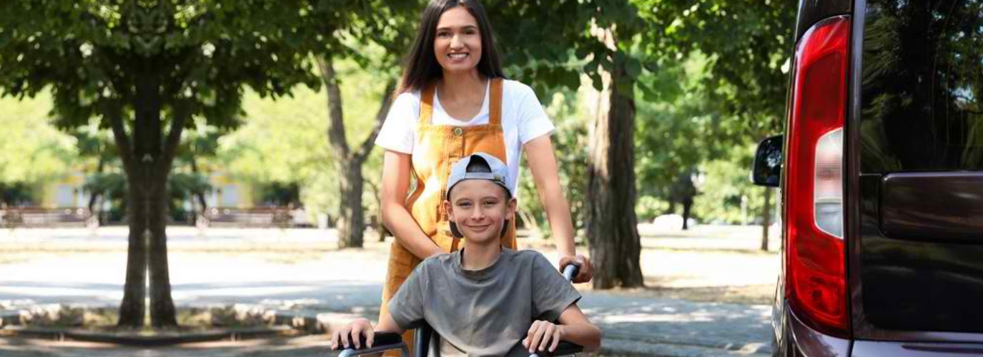 woman and a boy in a wheelchair smiling